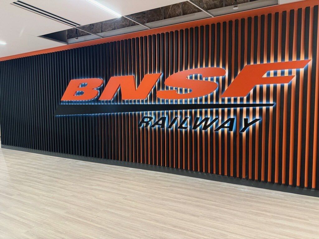 Backlit BNSF Railway logo wall on slat panel background