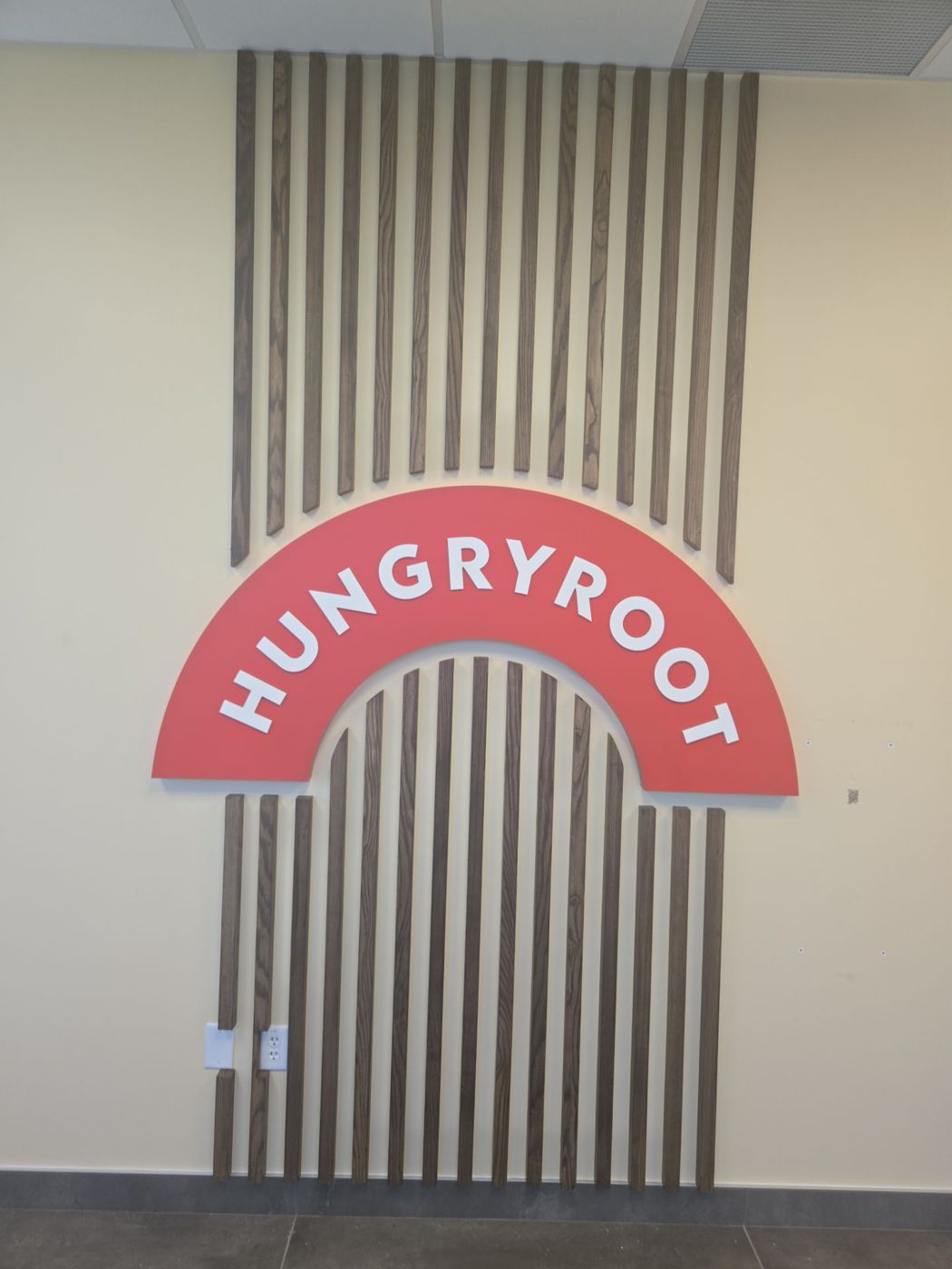Hungryroot dimensional logo on wood slat feature wall